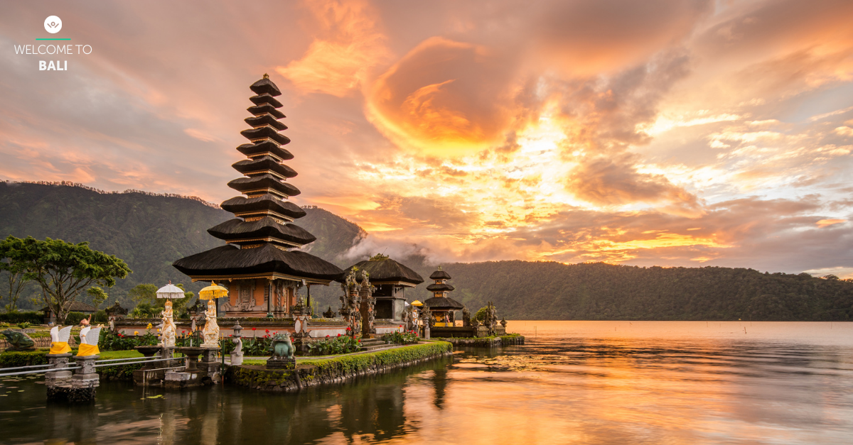 Hindu temple near body of water in Bali, under a cloudy sky during sunset